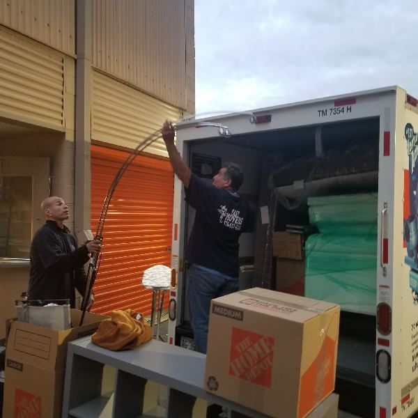 A man is loading boxes into a home depot truck