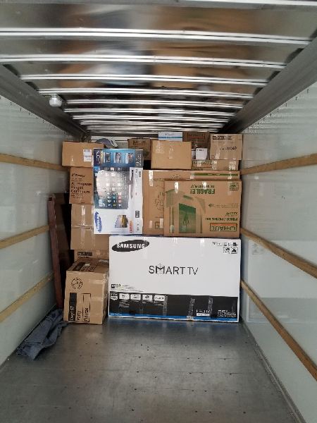 A truck filled with boxes and a smart tv