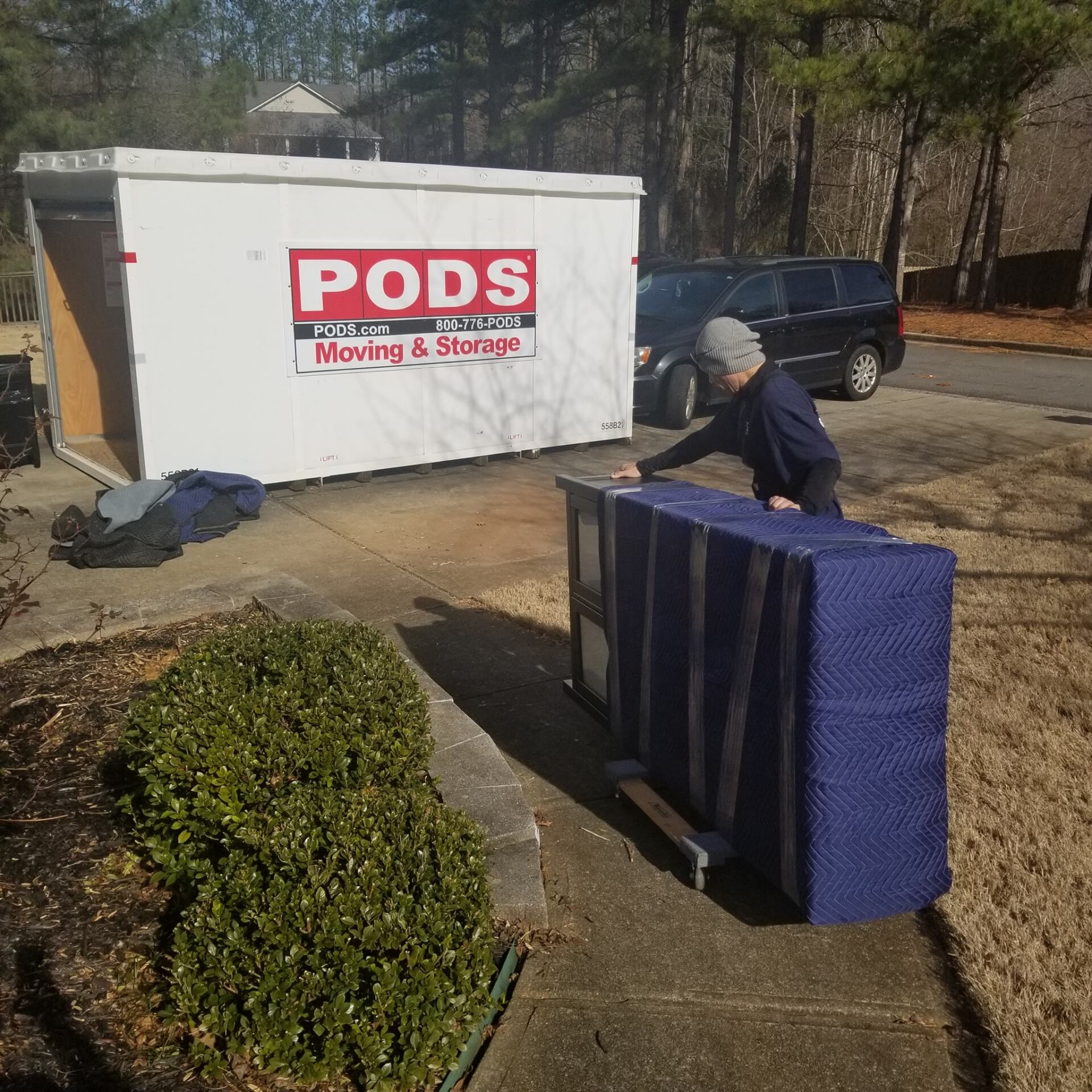 A pods moving and storage truck is parked on the side of the road