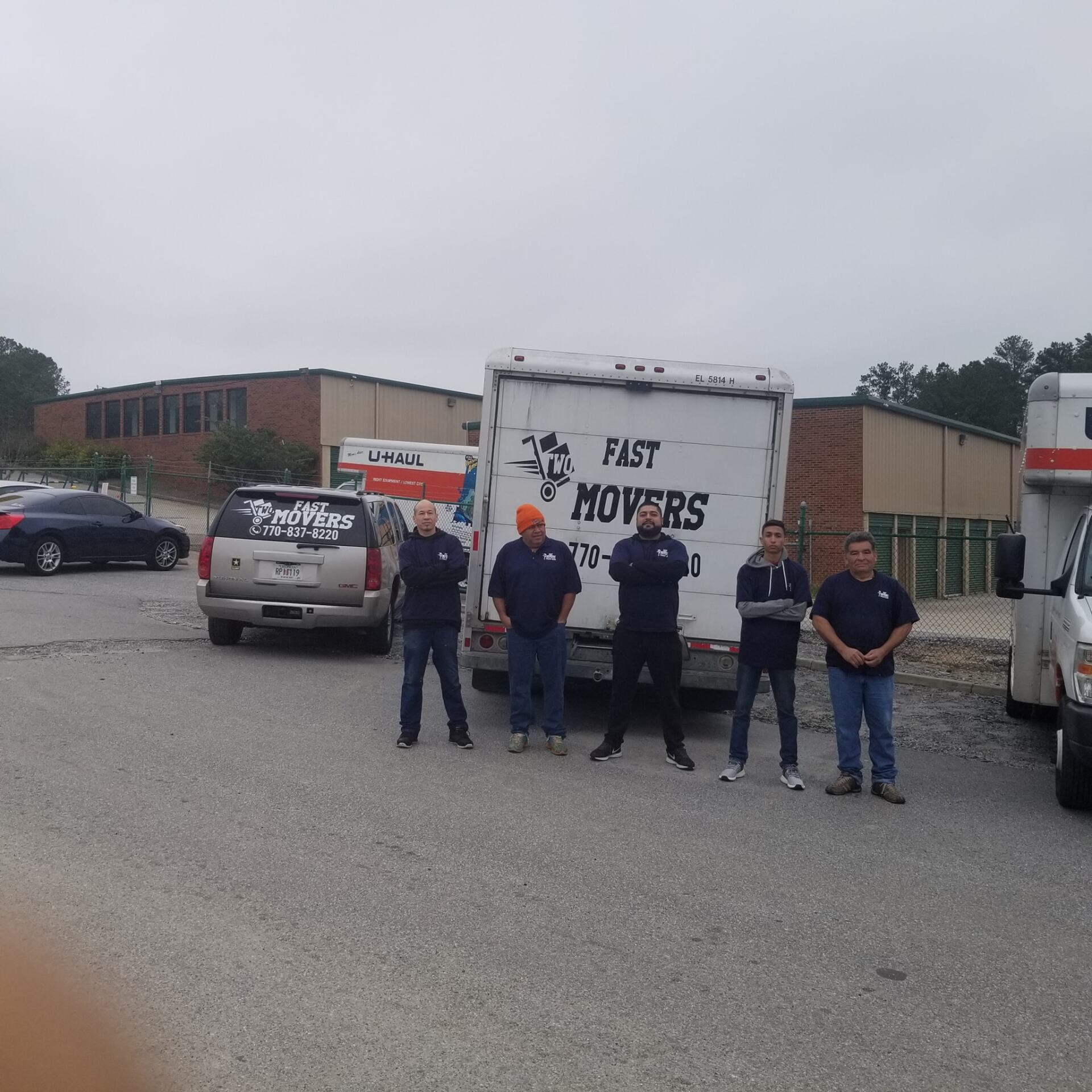 A group of men standing in front of a fast movers truck