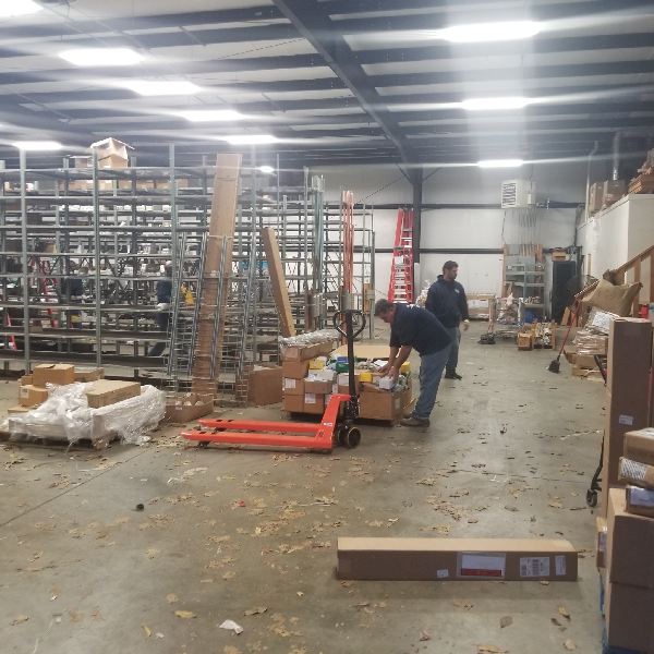A man is pushing a pallet truck in a warehouse