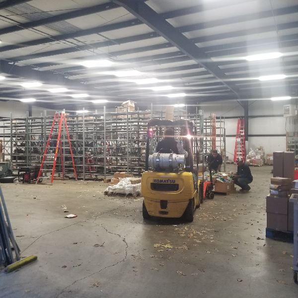 A yellow forklift is in a large warehouse