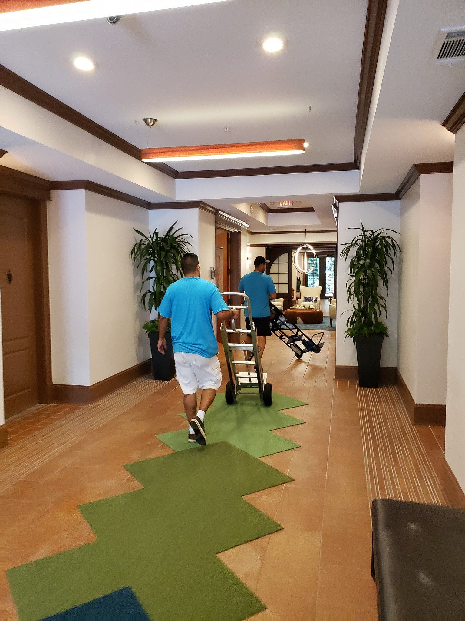 Two men are pushing a cart down a hallway.