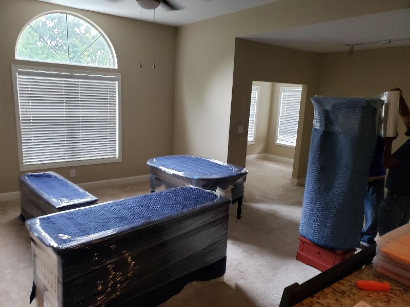 A living room with two trunks wrapped in blue plastic