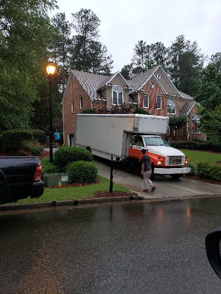 A moving truck is parked in front of a house
