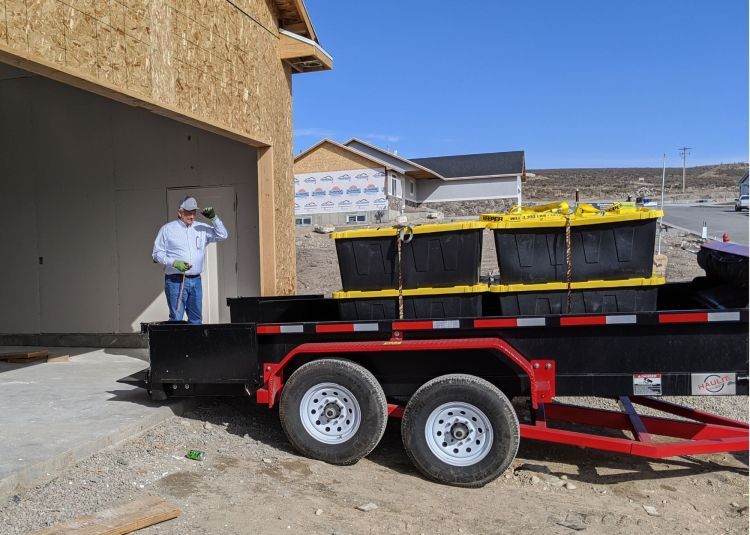 A man is standing next to a trailer loaded with boxes