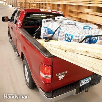 A red ford pickup truck is loaded with lumber