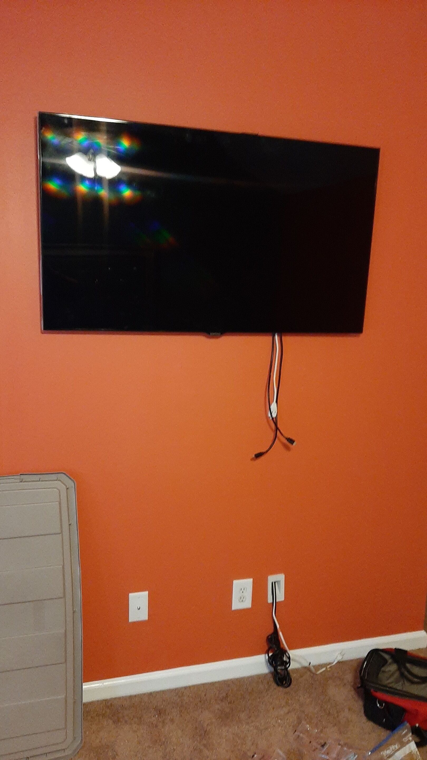 A flat screen tv is mounted on a wall in a living room.
