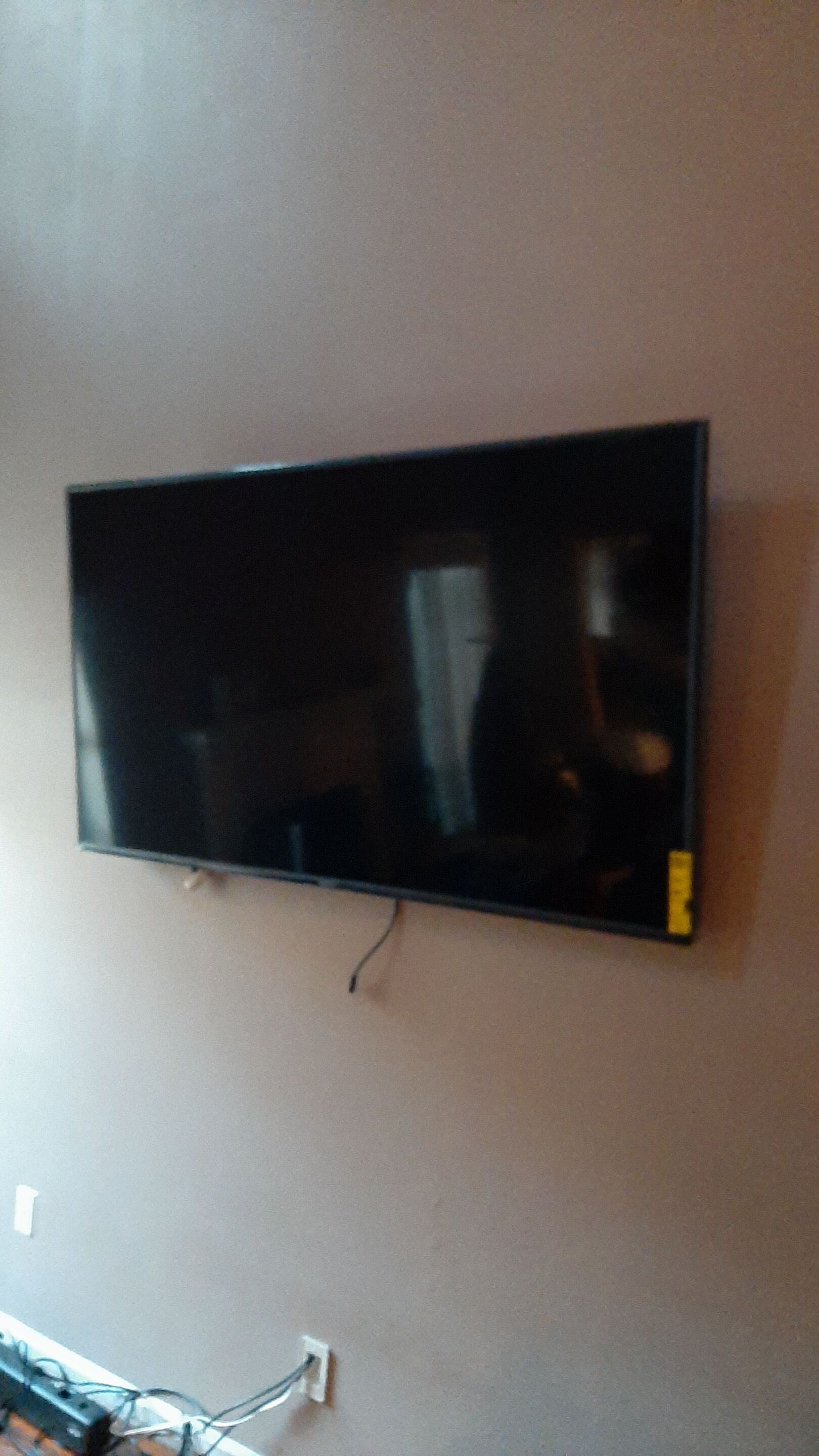 A flat screen tv is hanging on a wall in a living room.