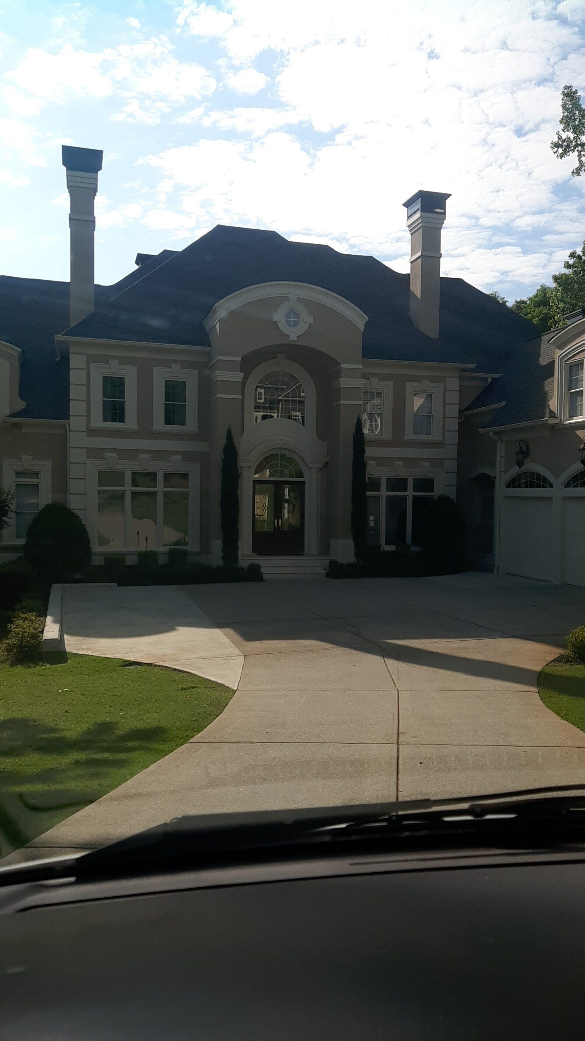 A view of a large house from inside a car.