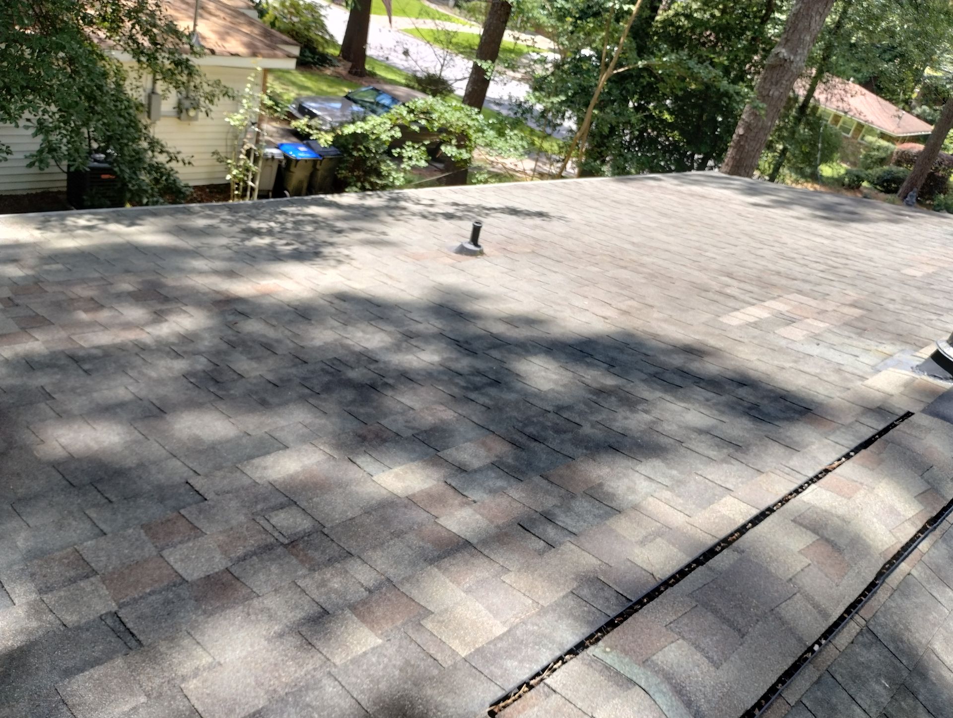 A close up of a roof with trees in the background.