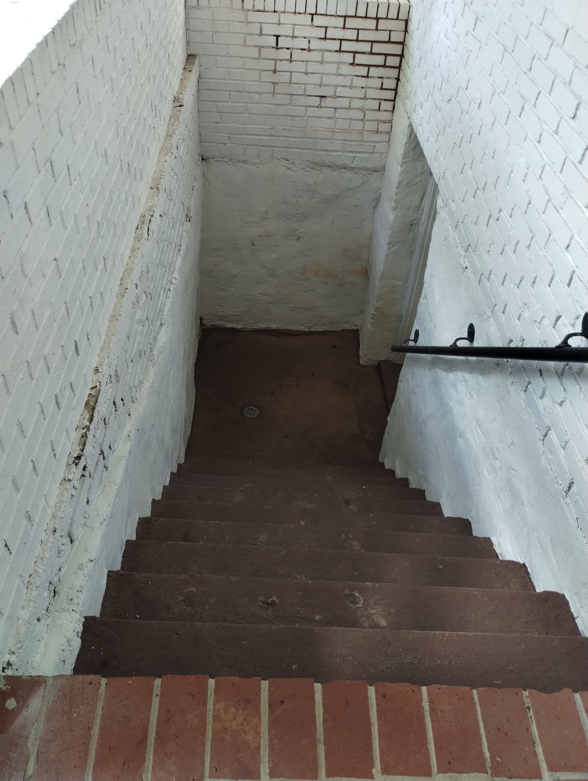 A set of stairs leading up to a white brick wall