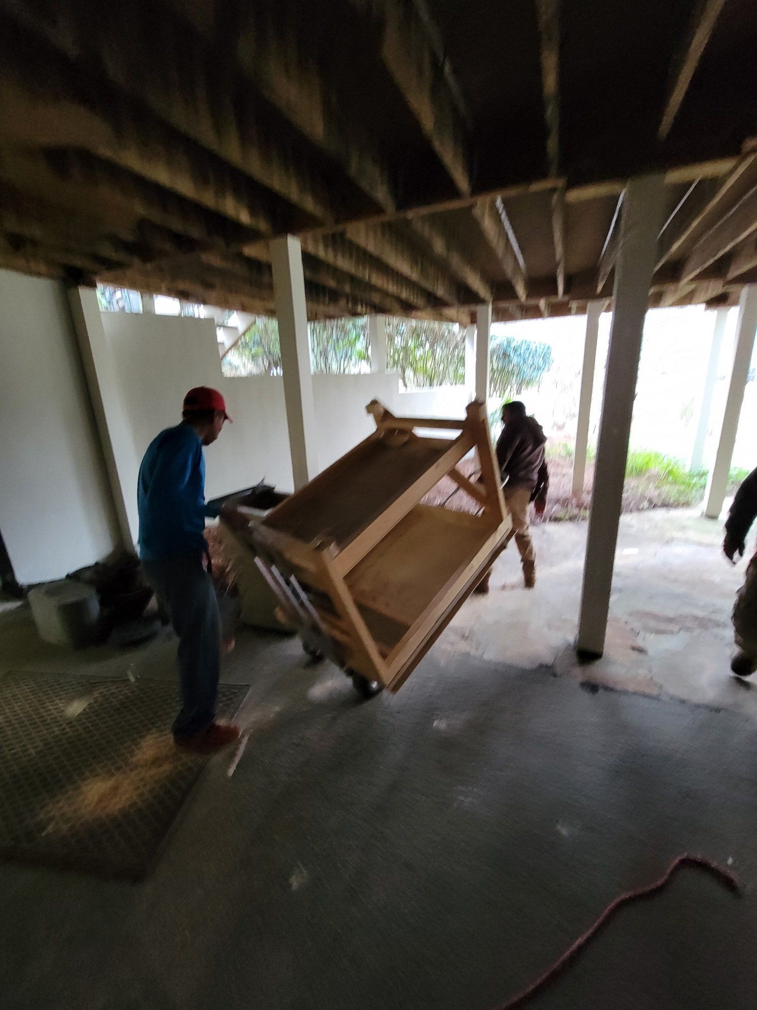A man is carrying a wooden table in a room