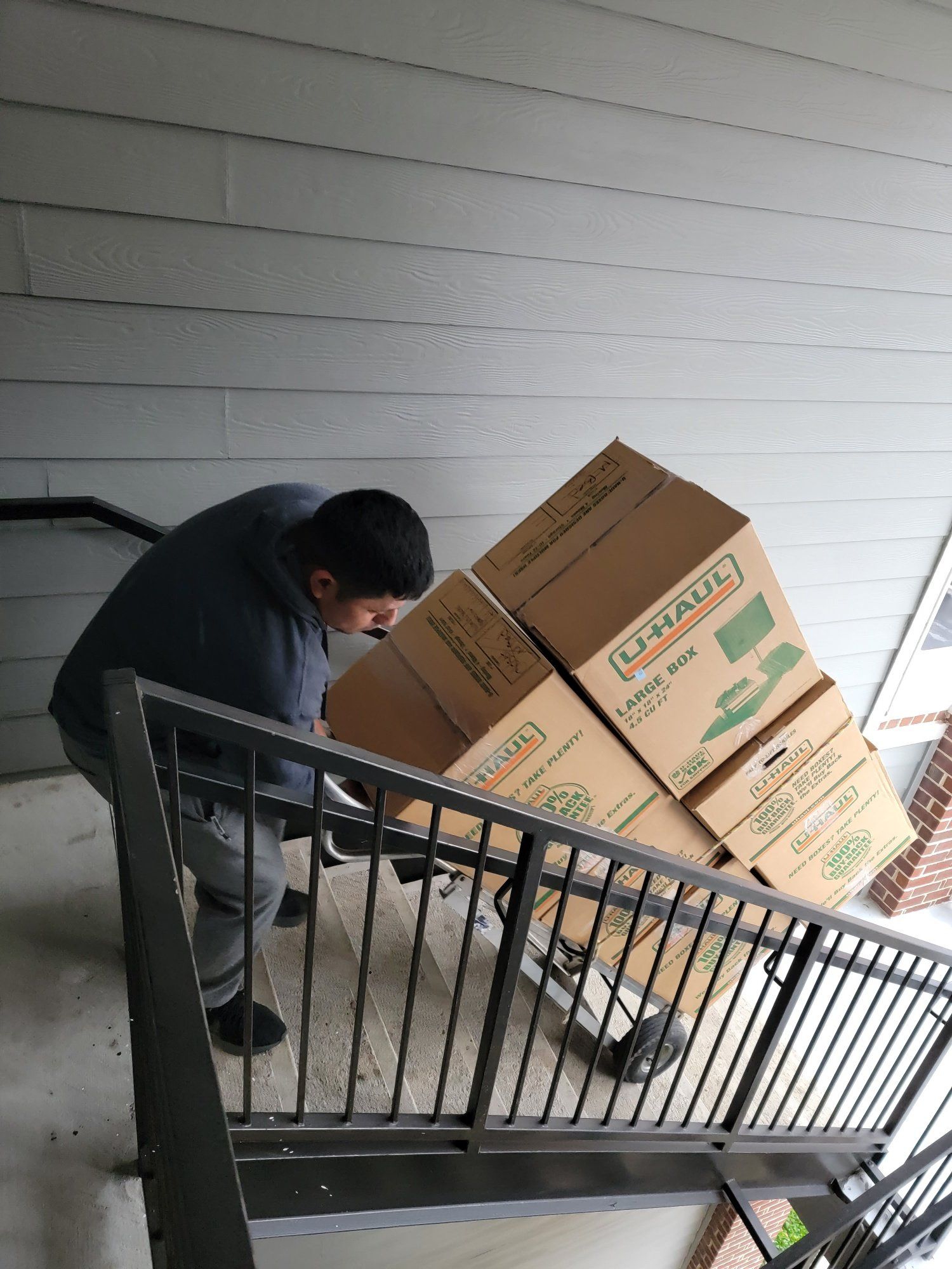 A man is carrying boxes up a set of stairs.