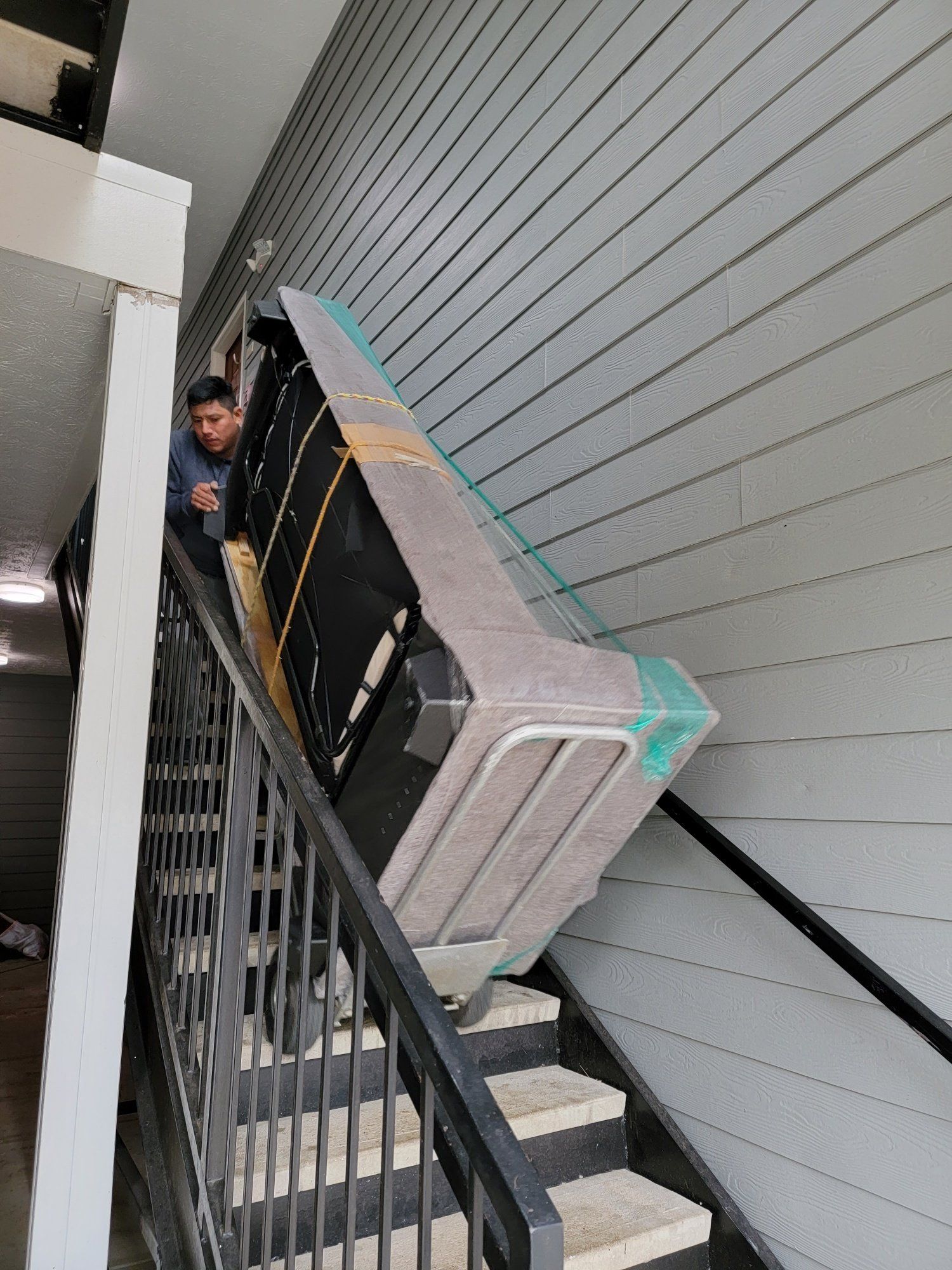 A man is carrying a couch up a set of stairs.