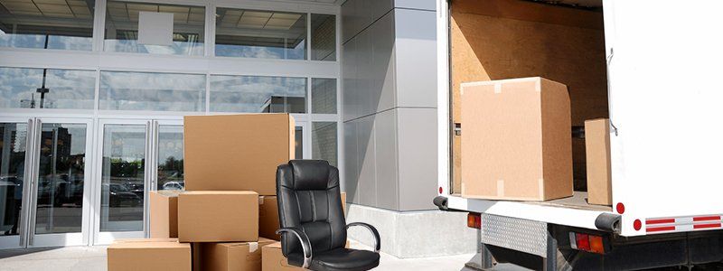 A moving truck is filled with boxes and a chair.