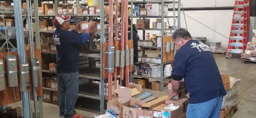 Two men are working in a warehouse.