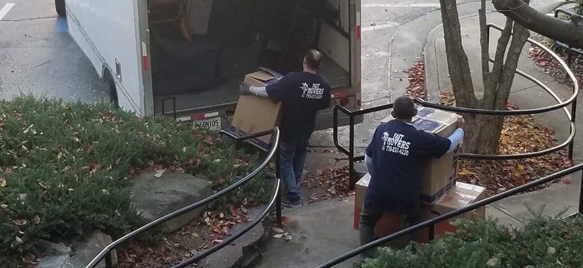 Two men are loading boxes into a truck.