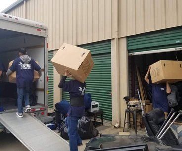 A group of people are loading boxes into a truck.