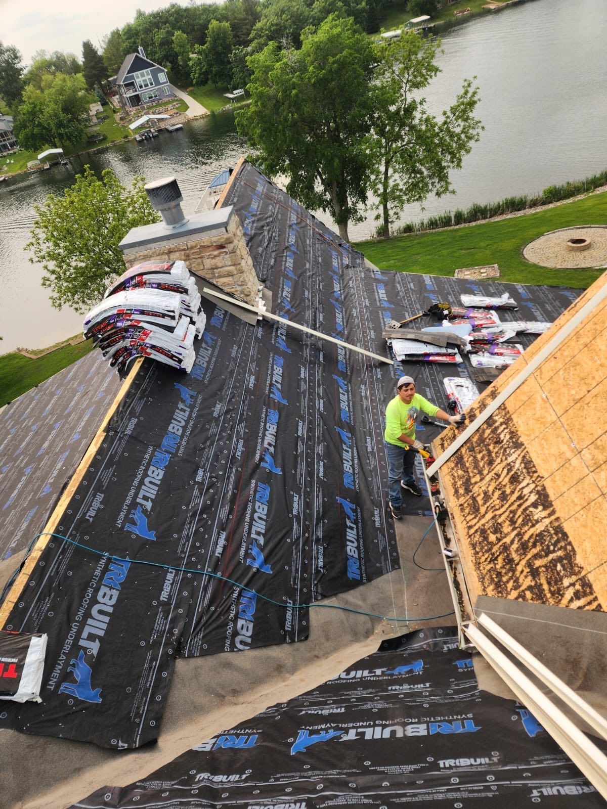 Two-story gray house with a freshly poured concrete driveway. One garage door is open.