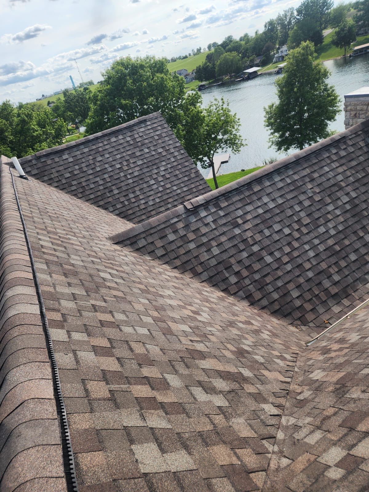 Two workers installing solar panels on a rooftop at sunset, with hills in the background.