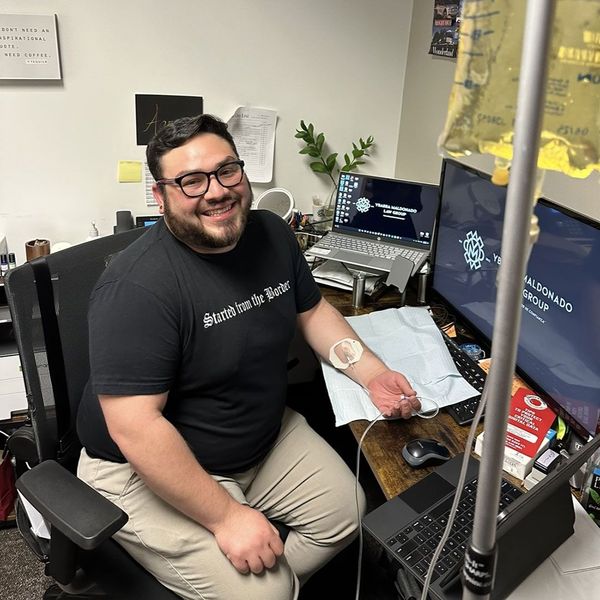Office worker getting IV hydration treatment at his workstation