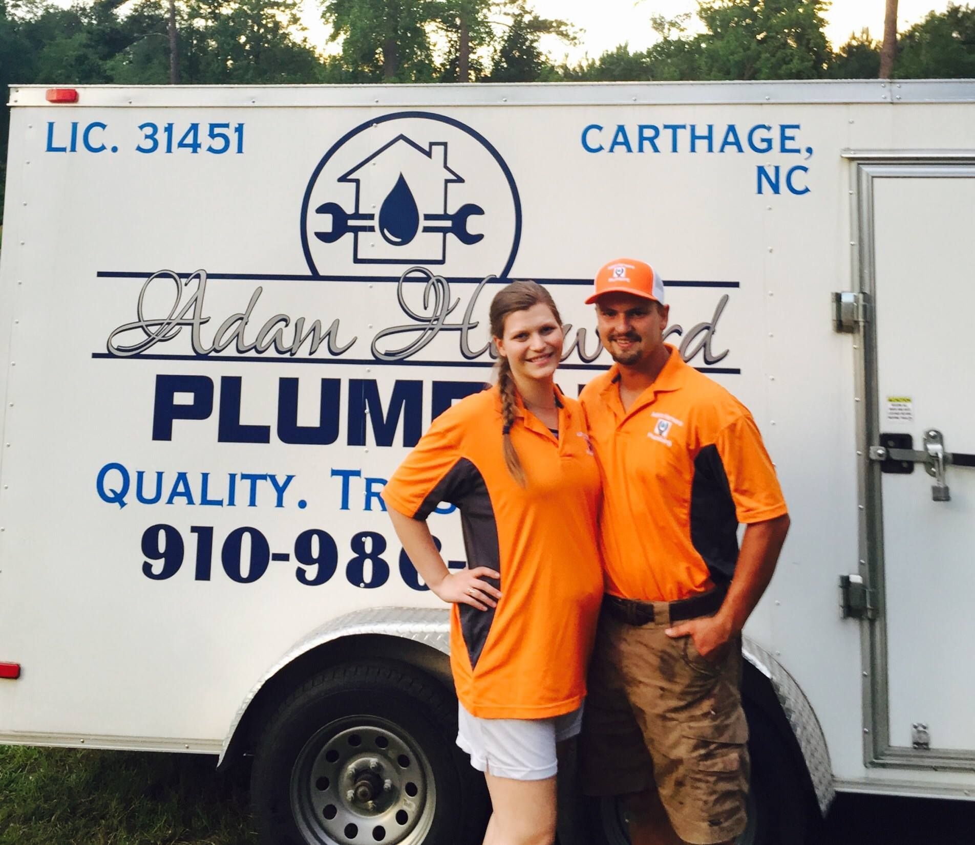 A man and two women are standing next to each other holding cleaning supplies.