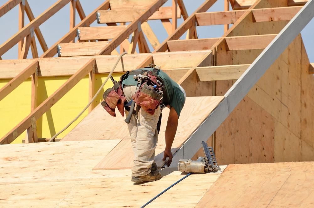 A Man Is Working on The Roof of A House — Trussframe in Scone, NSW