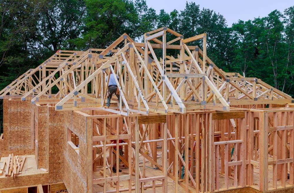 A Man Is Working on The Roof of A House — Trussframe in Narrabri, NSW