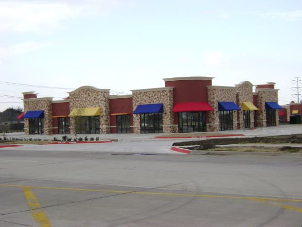 Commercial building with red, stone, and colorful awnings.