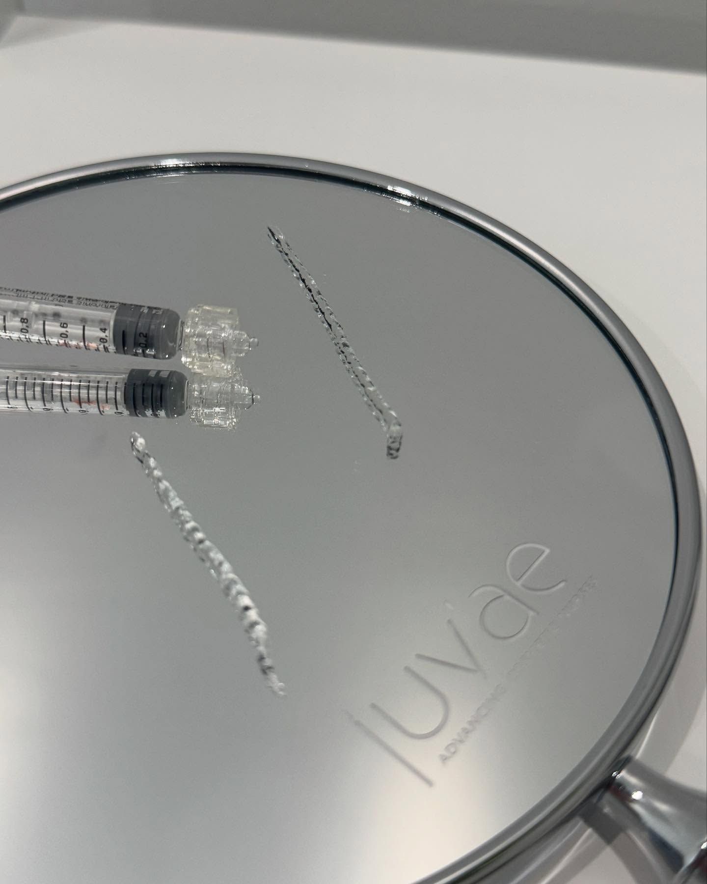 Two Syringes and Three Lines of Clear Gel on a Silver Mirror — Skin Haven Aesthetics Whitsundays in Airlie Beach, QLD