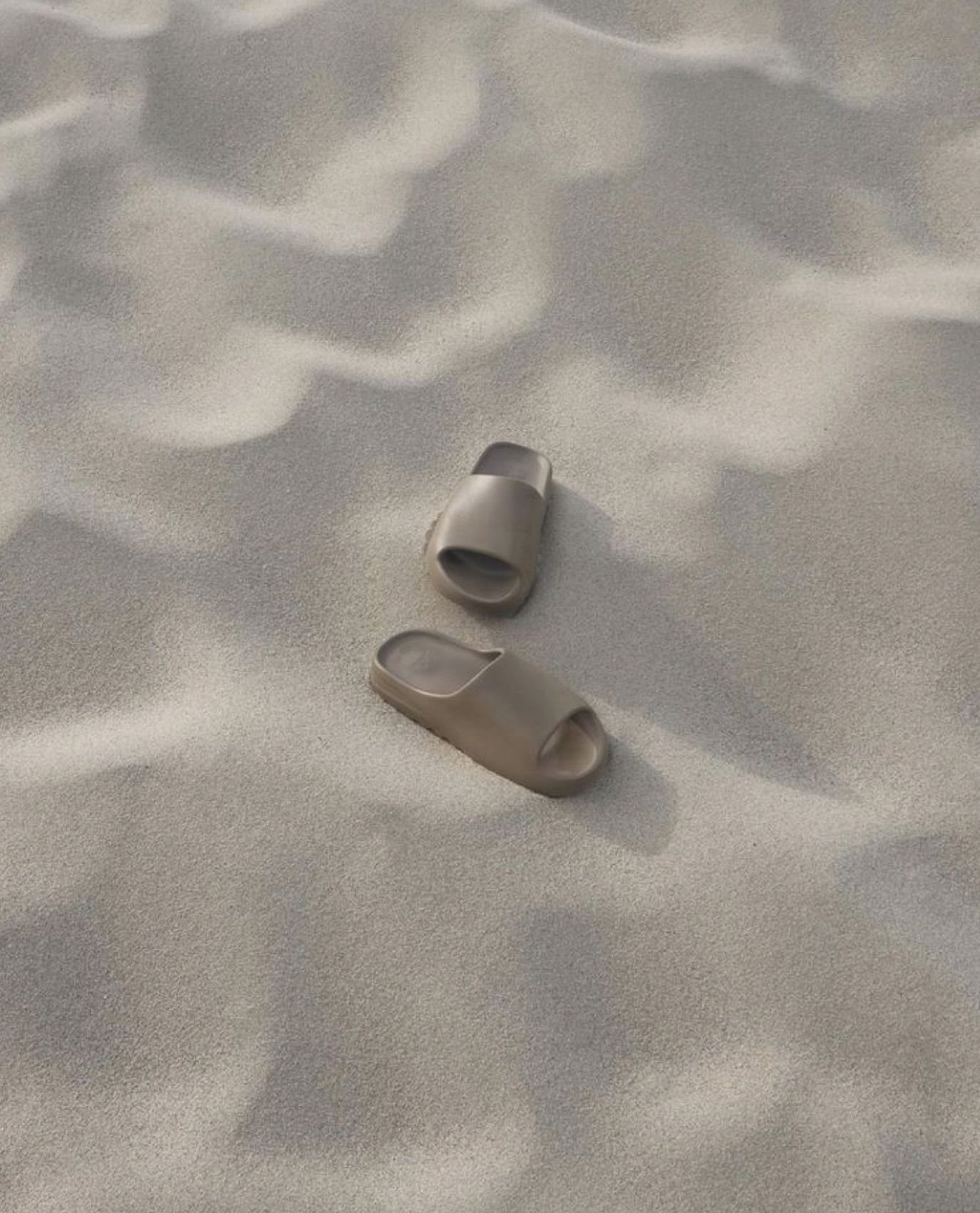 Tan sandals on textured beige sand.— Skin Haven Aesthetics Whitsundays in Airlie Beach, QLD