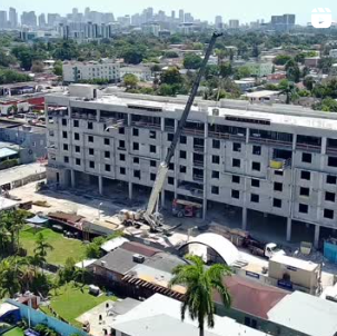 An aerial view of a large building under construction in a city.