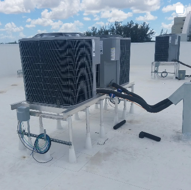 Two air conditioners are sitting on top of a white roof