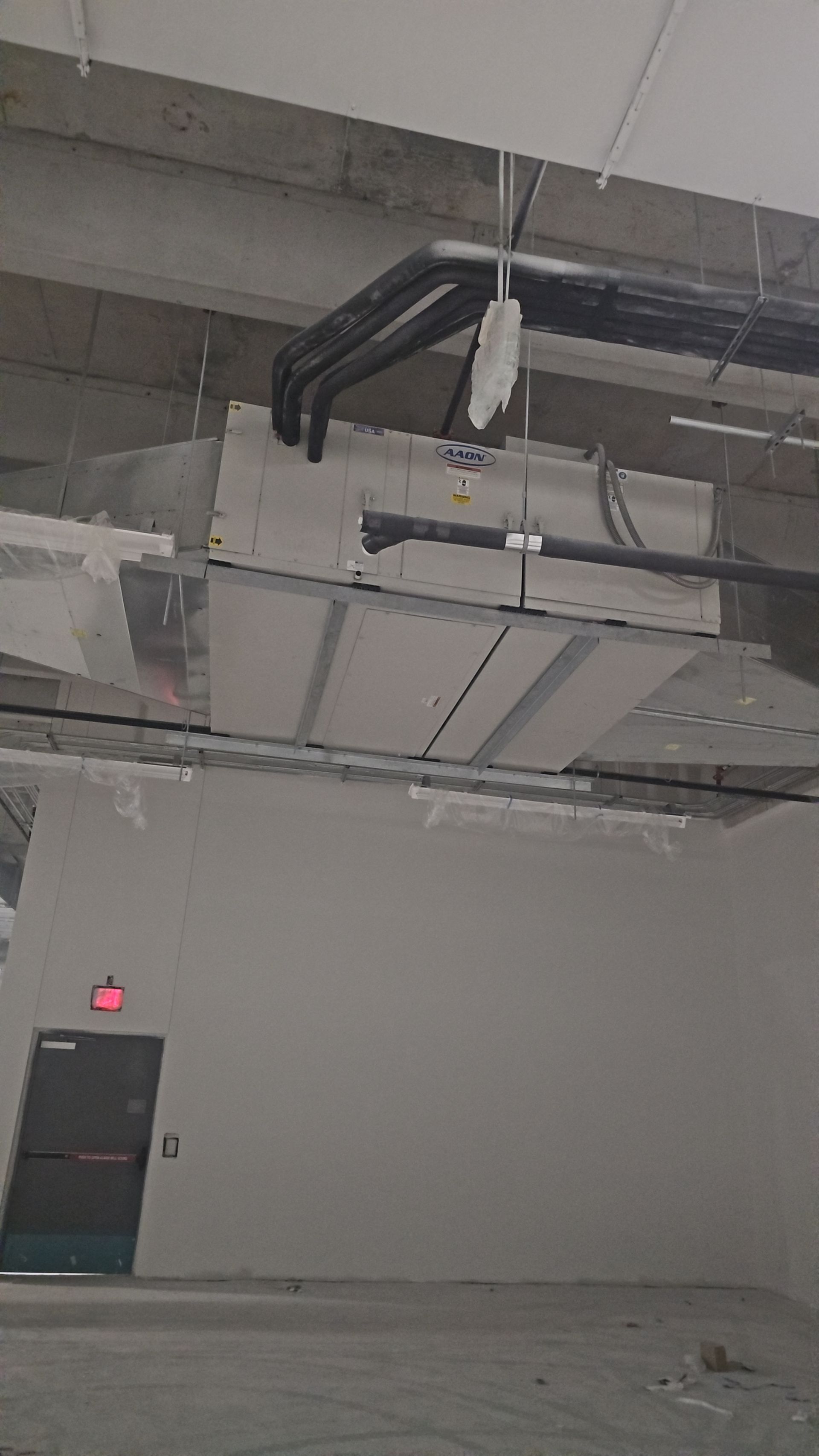 A room with a lot of pipes hanging from the ceiling.