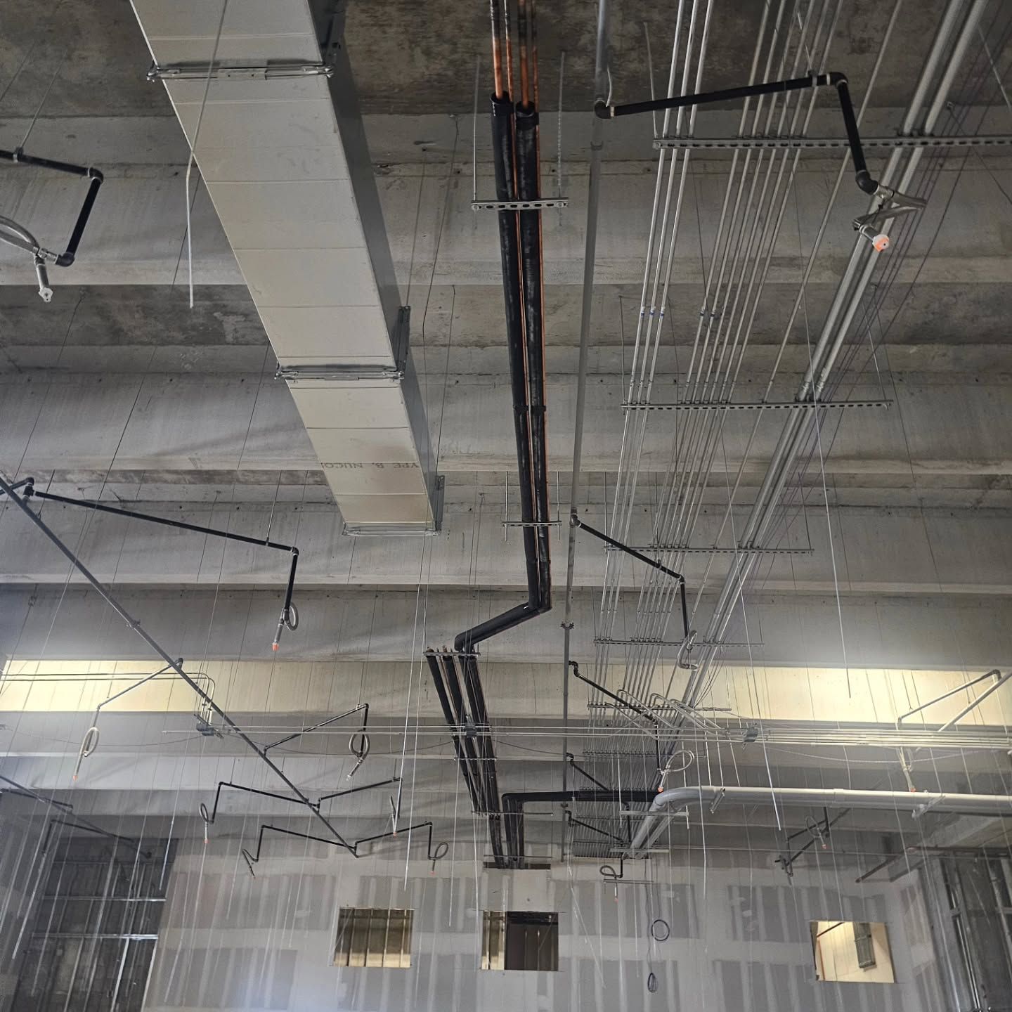 A ceiling with a lot of pipes hanging from it