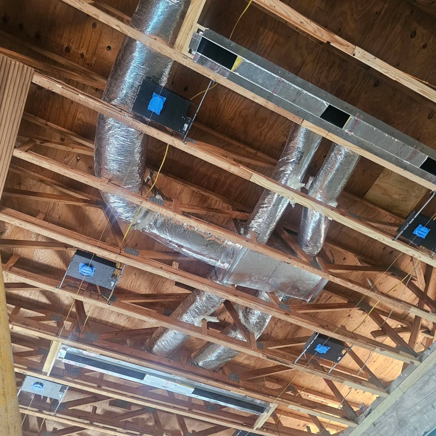 A ceiling with a lot of pipes hanging from it.