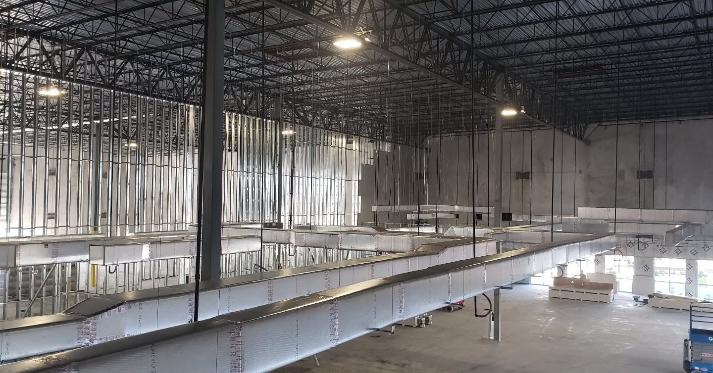 A large warehouse under construction with a conveyor belt going through it.