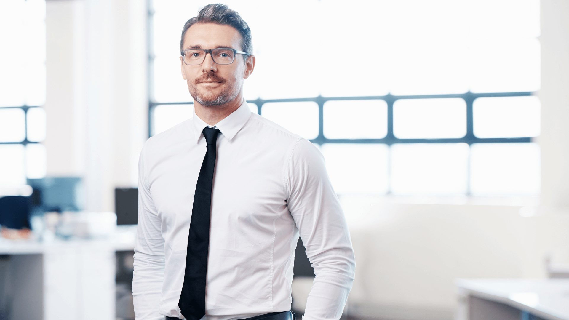 A woman is sitting at a table using a laptop computer.