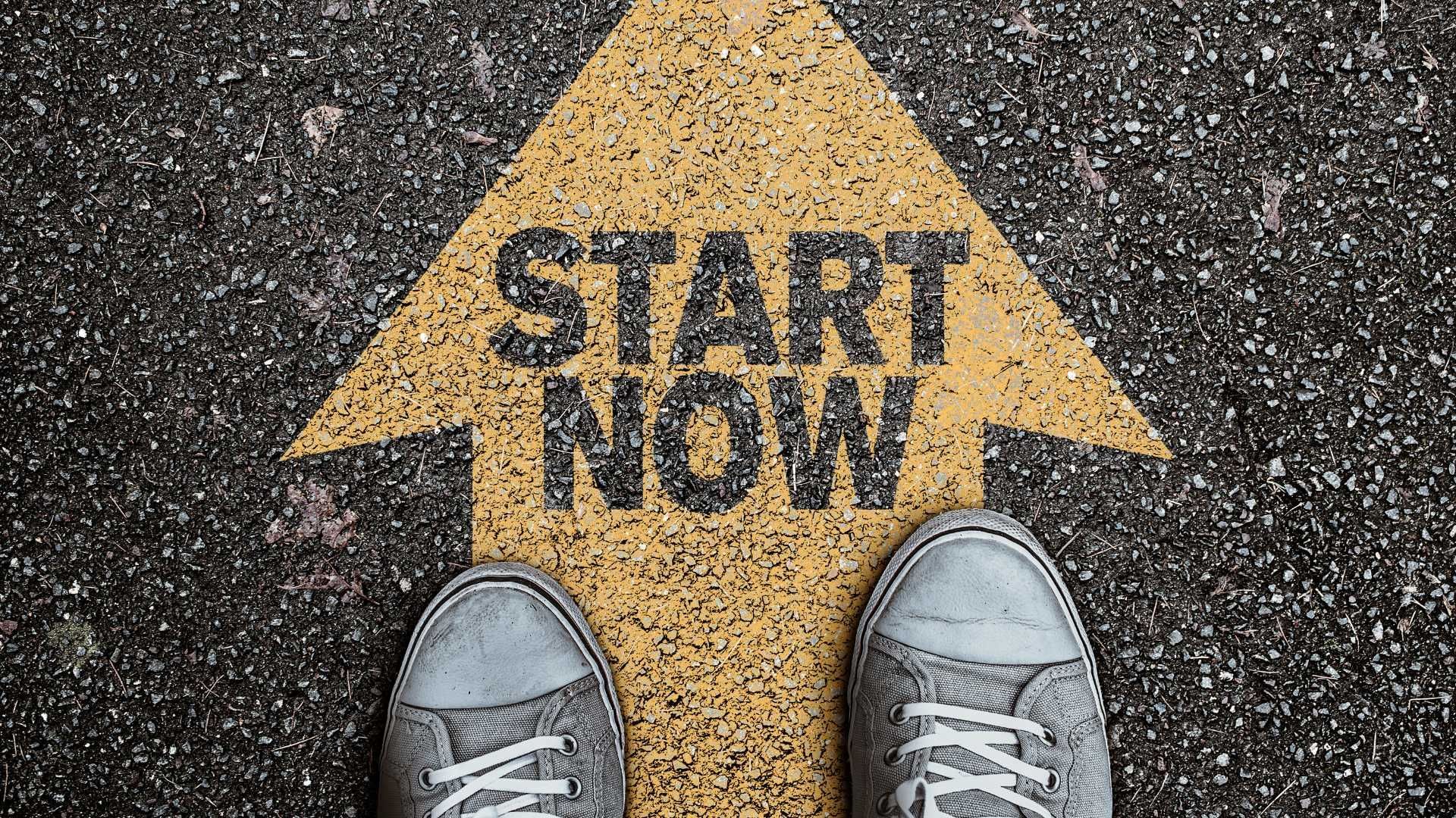 A pair of shoes standing next to a yellow arrow that says 'start now'