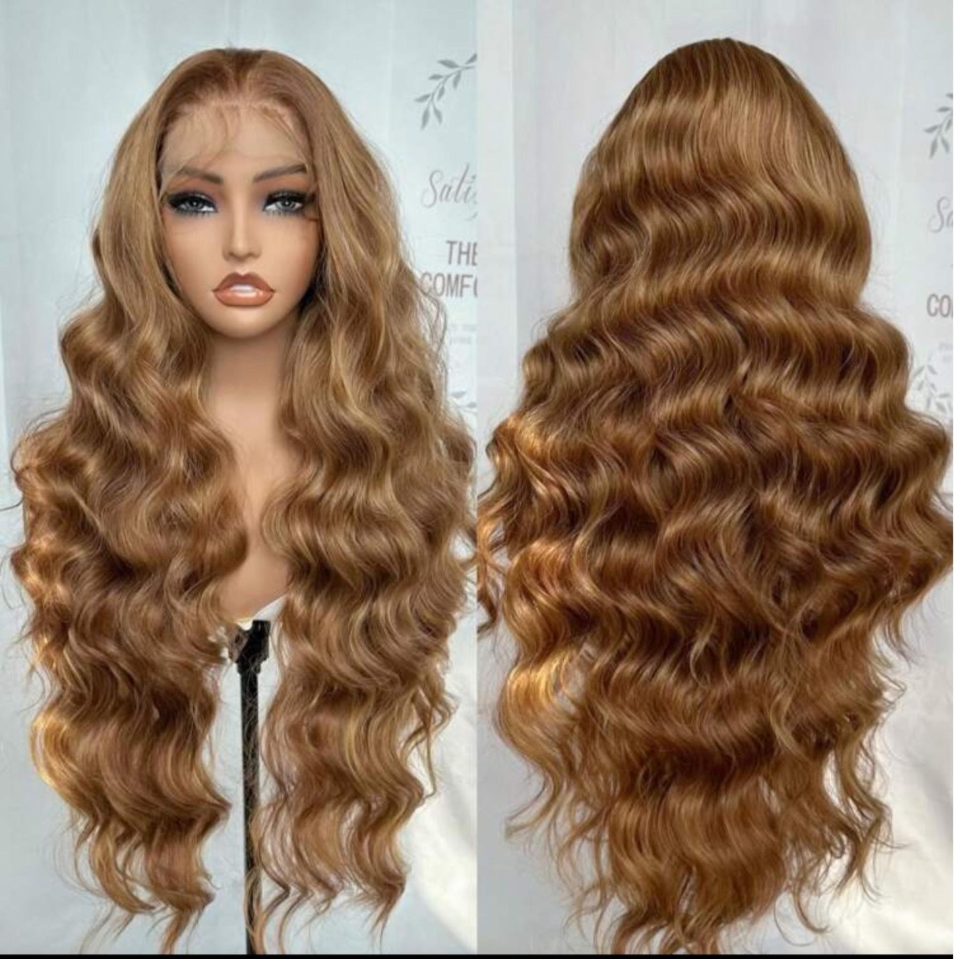 Una cabeza de maniquí muestra una peluca larga, ondulada y de color marrón dorado, vista desde el frente y desde atrás, sobre un fondo neutro.