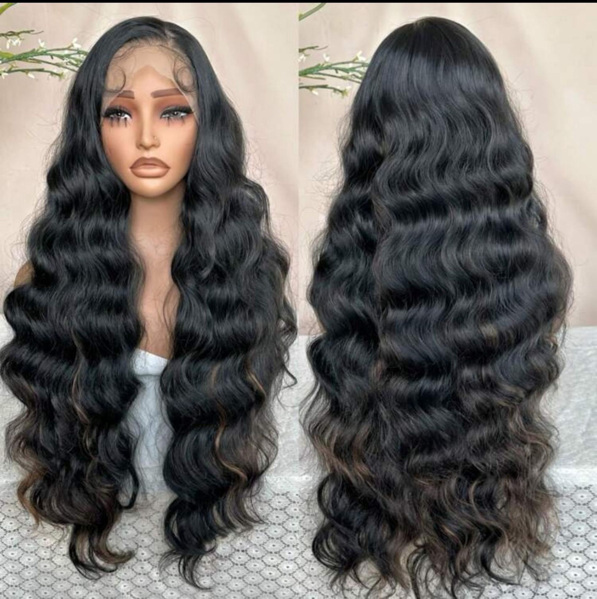 Una peluca larga, ondulada y negra con encaje frontal, mostrada desde el frente y la parte posterior en una cabeza de maniquí.