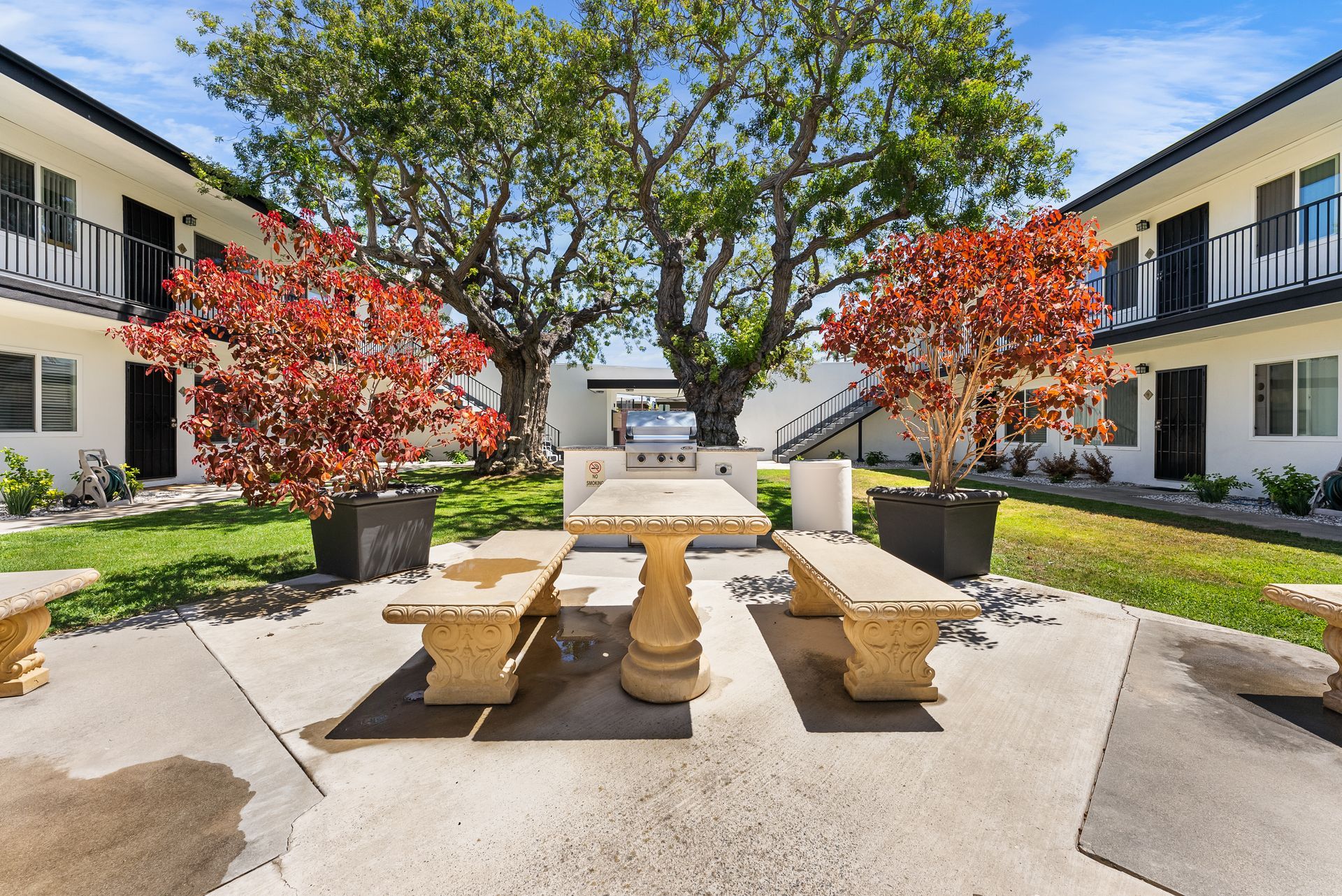picnic table and umbrella with grill from straight on