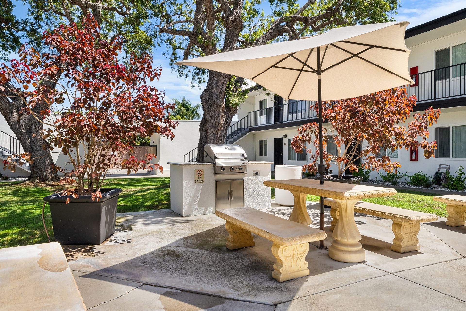 picnic table and umbrella with grill from diagonal angle