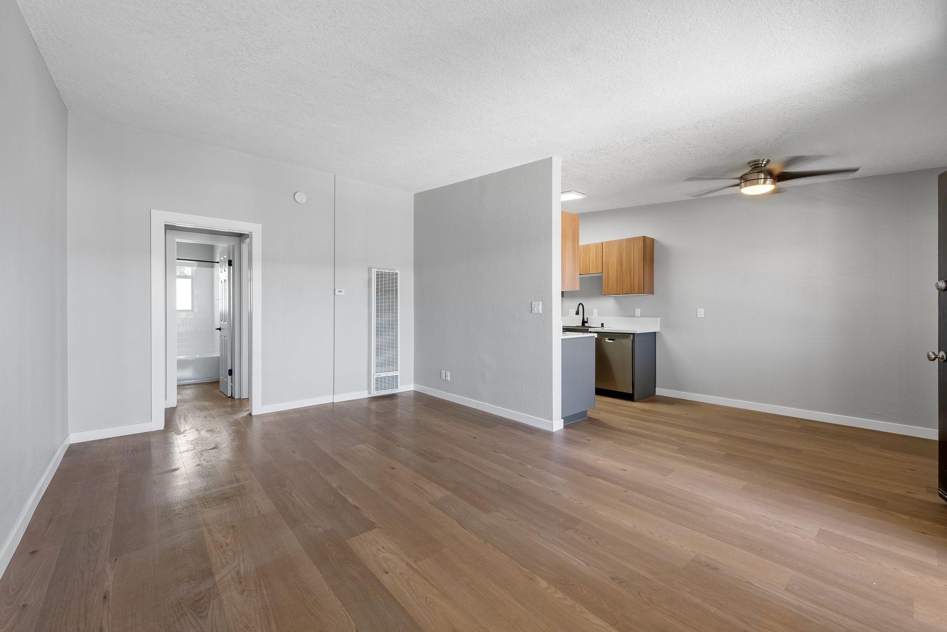 Living room with view into hallway through doorway and peak of kitchen