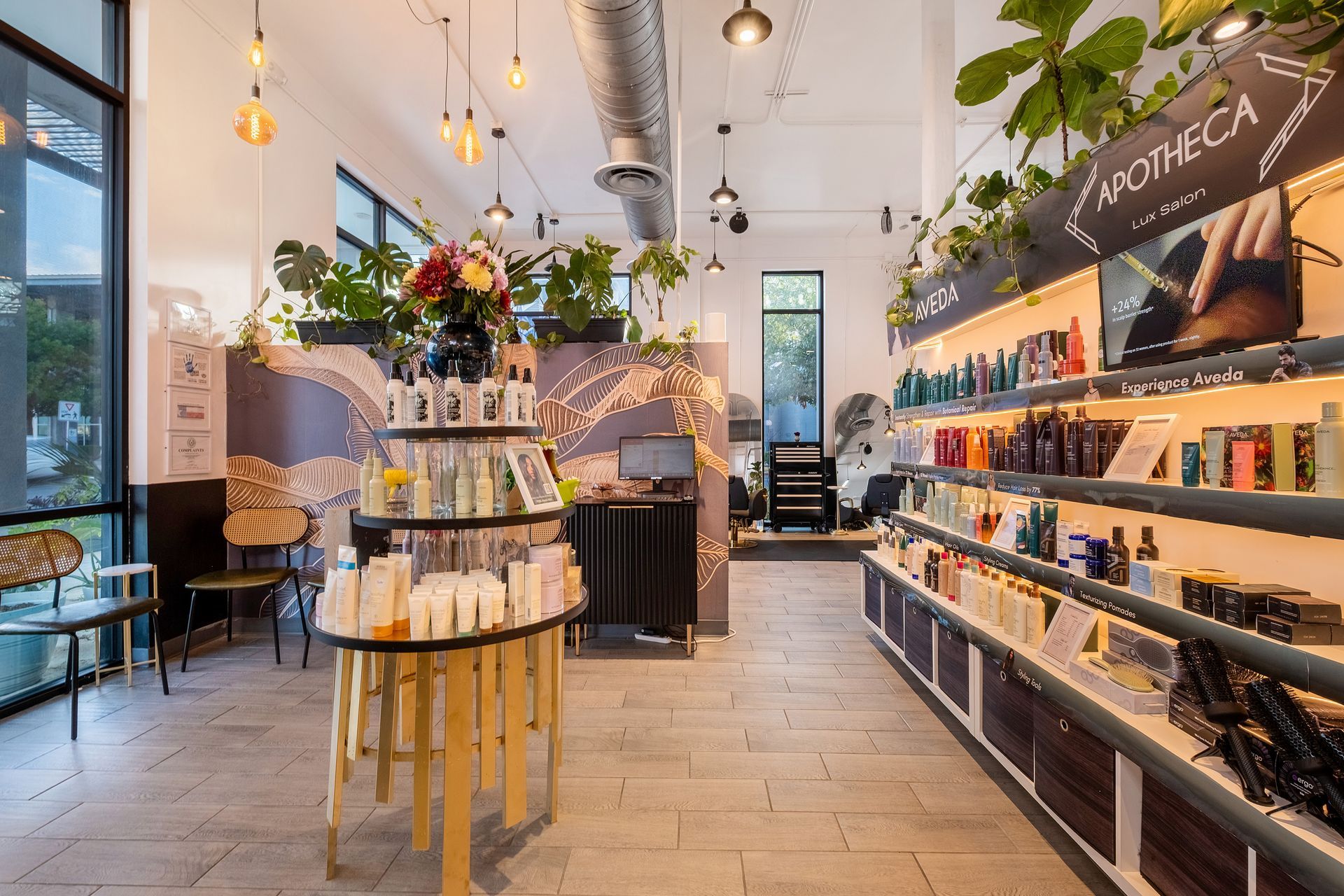 Interior of a beauty product shop with shelves of items, plants, and round display.