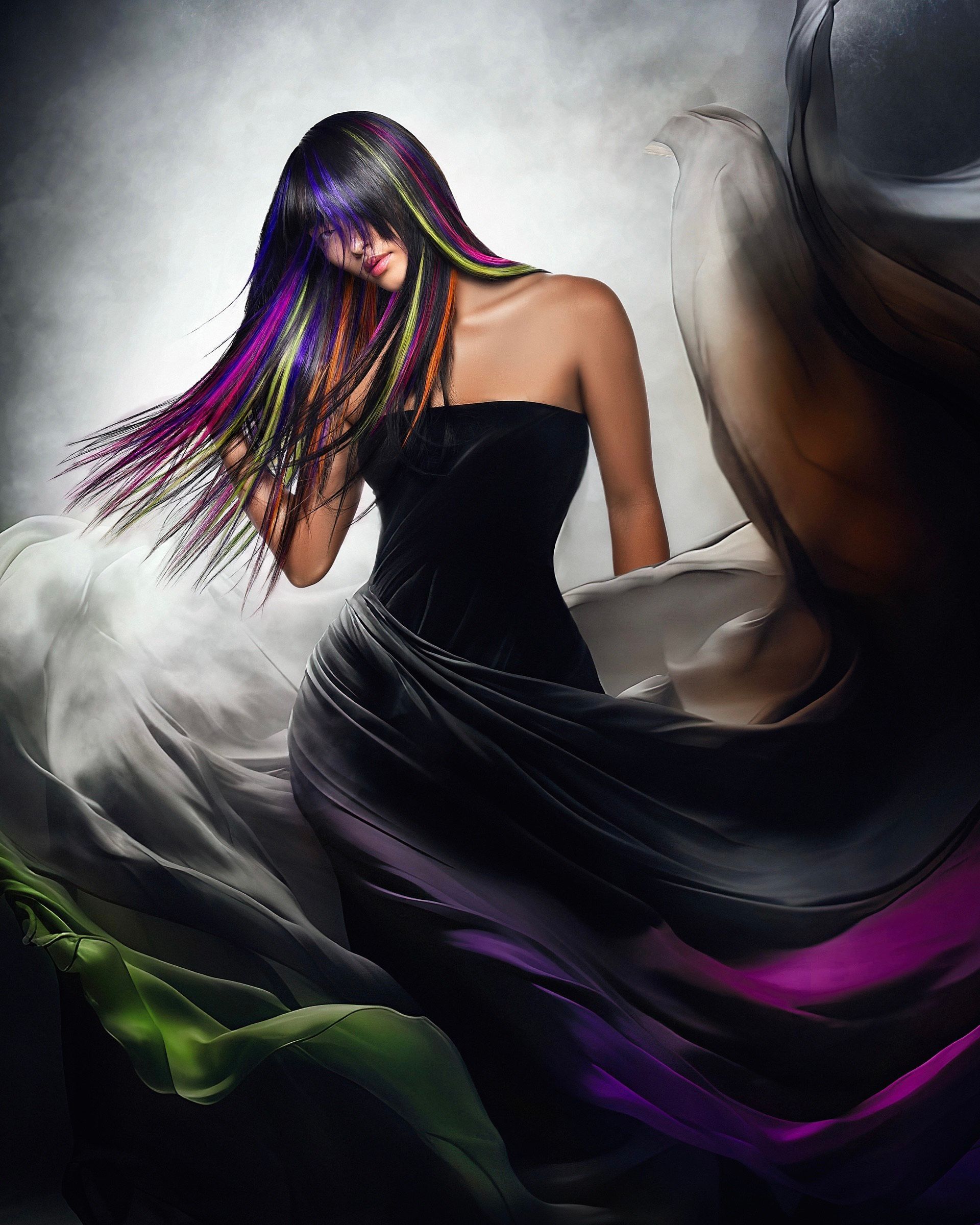 A woman in a black dress with purple and green hair