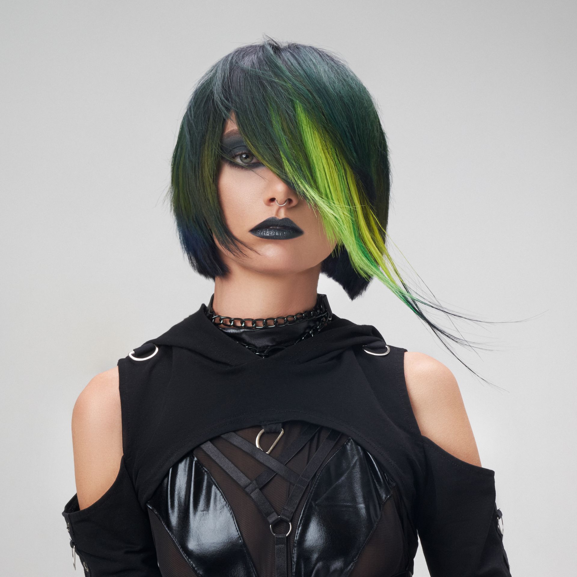 A woman with green hair is wearing a black top