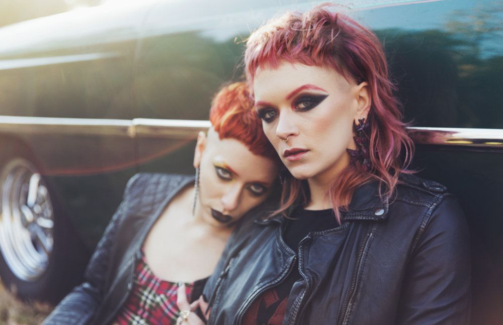 Two women with red hair are sitting next to each other in a car.