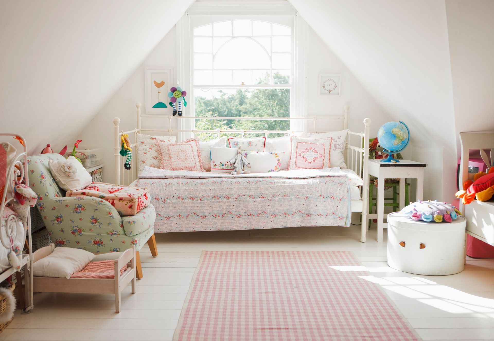 a child 's bedroom with a day bed , chair , and globe .